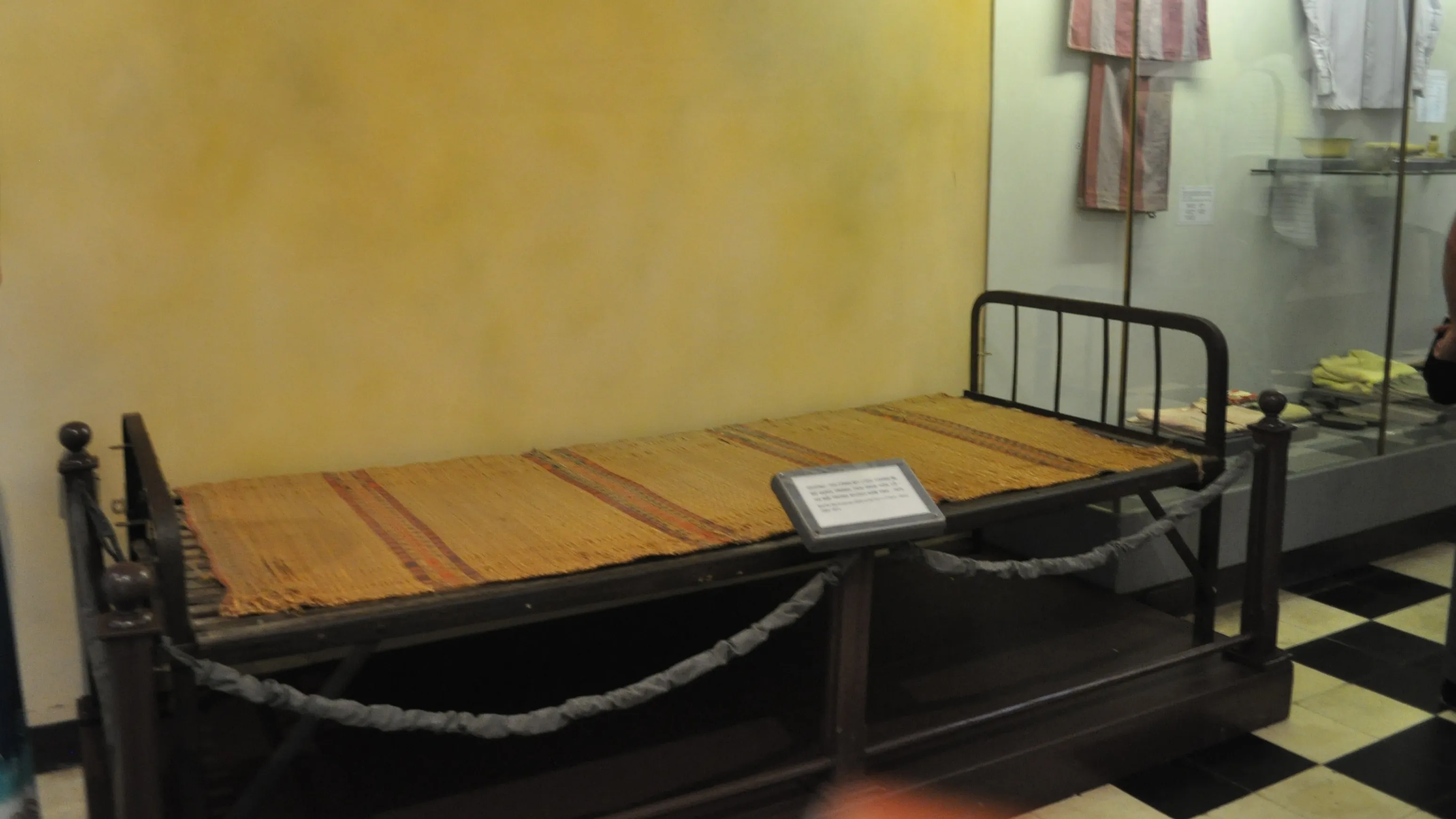 Iron shackle-bar sleeping platforms inside Hoa Lo Prison (the Hanoi Hilton) in Hanoi, Vietnam — the metal beds where political prisoners were chained by the ankles during the French colonial era