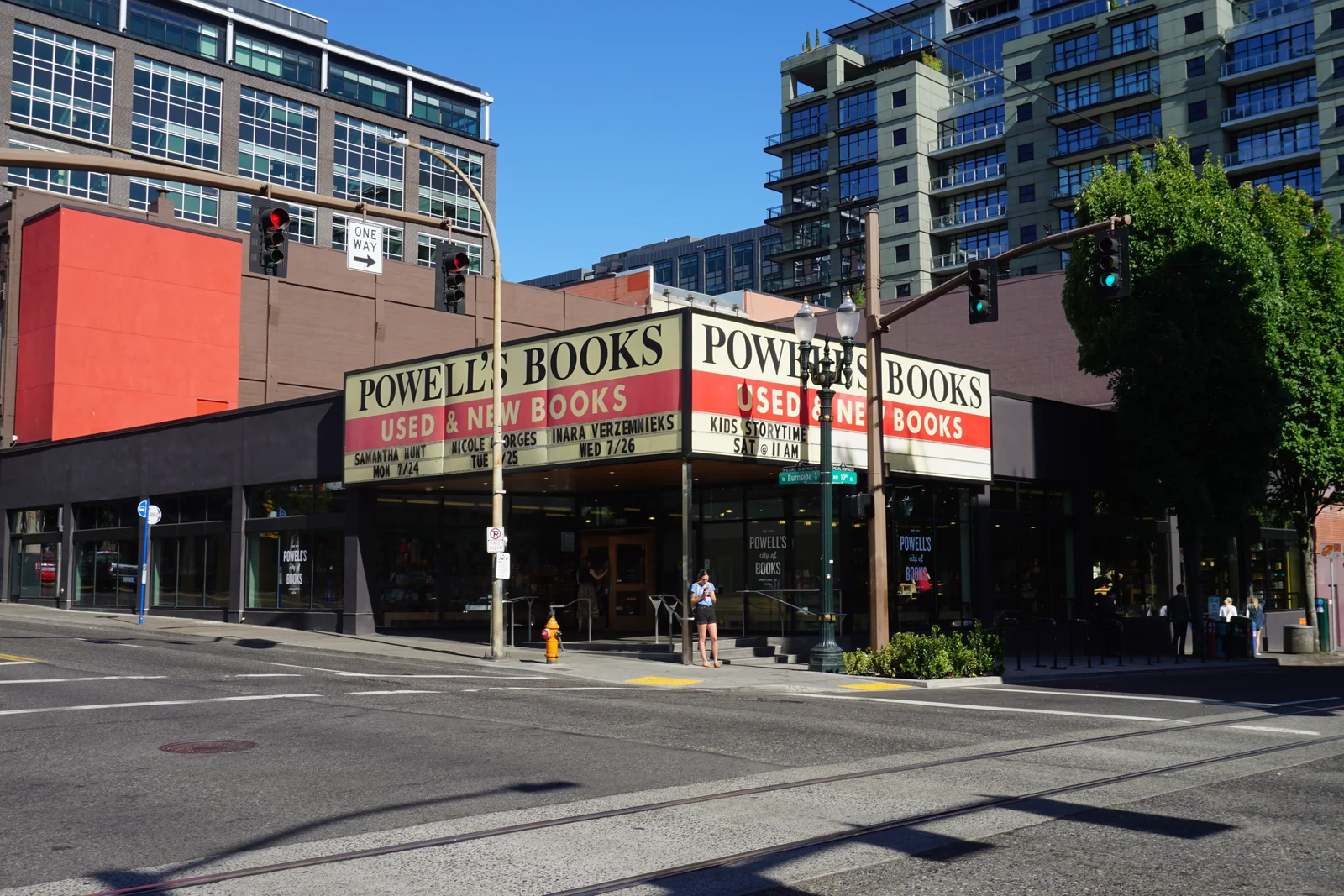 Yellow Powell's Books marquee wrapping the corner entrance of the bookstore under a clear blue sky in Portland
