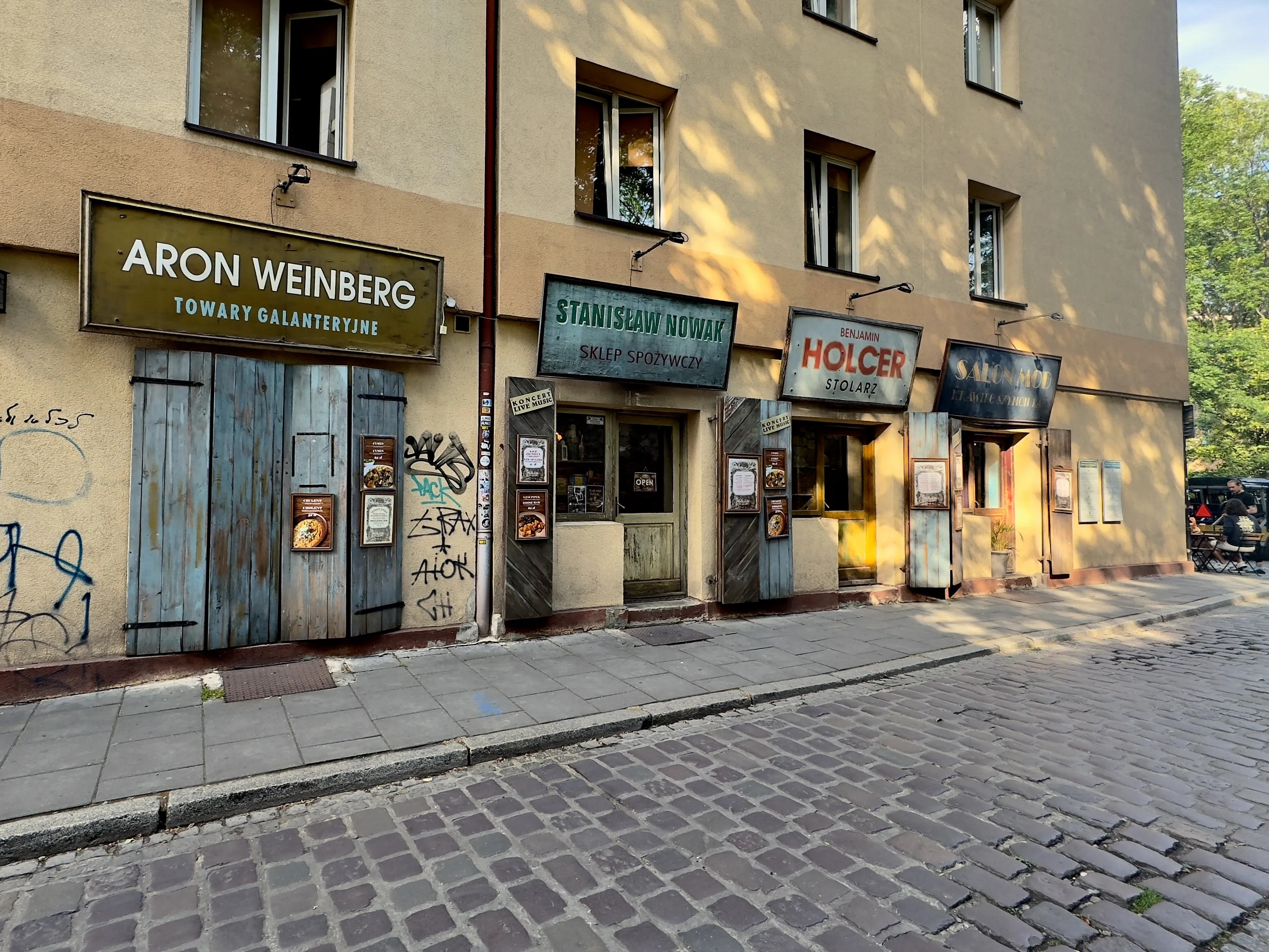 Colourful facades and café terraces on Szeroka Street in Kazimierz, Kraków's historic Jewish quarter, Poland