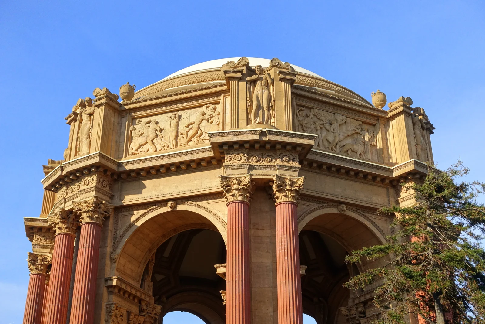 A weathered decorative relief panel on the Palace of Fine Arts depicting classical figures in low relief